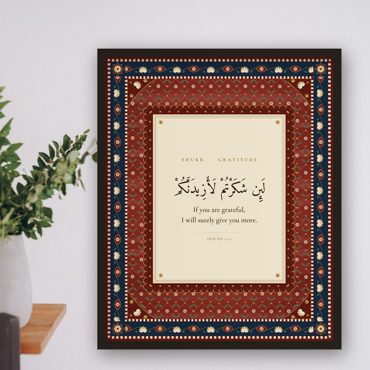 Shukr Islamic wall art framed on a shelf wall with a plant