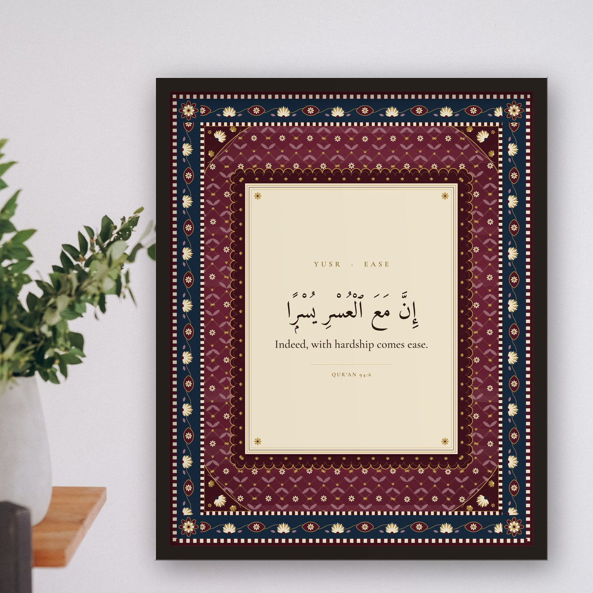 Yusr Islamic wall art framed on a shelf wall with a plant